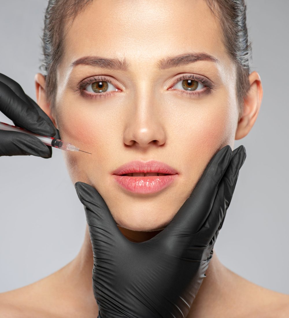 Young caucasian woman getting botox cosmetic injection near the eyes. Beautiful woman gets botox injection in her face. Adult girl gets cosmetic injection of botox in a clinic. Beauty treatments