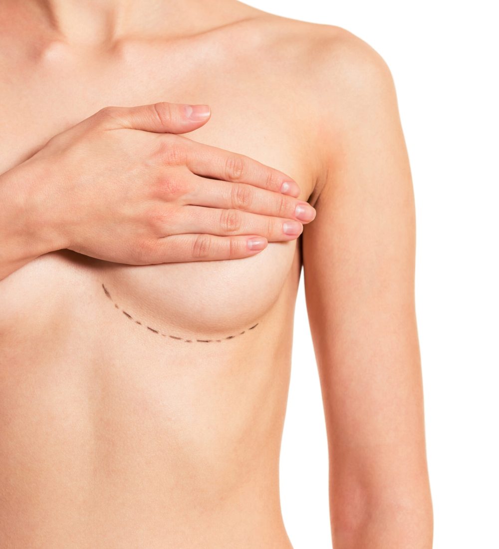 Beautiful naked young woman covering her breast with sketches under it, isolated on a white background, cropped